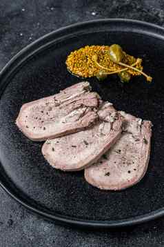 猪肉煮熟的舌头片板黑色的背景前视图