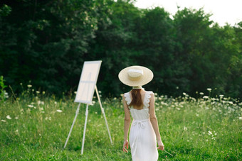 漂亮的女人白色衣服在户外画架艺术