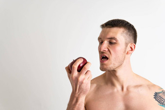 男人。持有苹果健身白色背景孤立的运动孤立的身体肌肉发达的饮食食物肌肉赤膊上阵高加索人持有素食者持有胸部