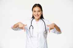 微笑亚洲女人医生指出手指显示促销交易折扣诊所服务医院广告白色背景