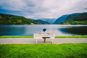 女人坐着板凳上峡湾于尔维克的<strong>酒店</strong>挪威峡湾沿海散步于尔维克的<strong>酒店</strong>Hordaland县挪威孤独的旅游他坐在回来板凳上欣赏风景斯堪的那维亚