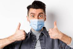 科维德健康生活方式概念特写镜头兴奋积极的的家伙医疗面具支持穿医疗面具流感大流行显示拇指批准