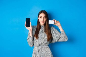 在线购物沉思的夫人衣服显示空电话屏幕塑料信贷卡订单<strong>互联网蓝色</strong>的背景