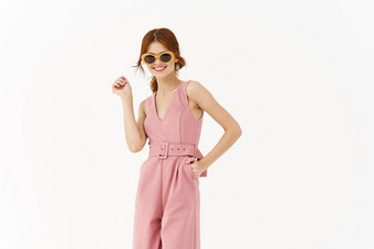 漂亮的女人粉红色的西装太阳镜时尚夏天风格摆姿势