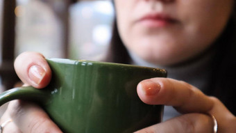 女孩饮料热喝早....女人持有杯茶咖啡嘴唇可重用的陶瓷绿色杯可可热牛奶