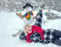 冬天女人问候雪人雪人有趣的女模型站冬天他围巾红色的鼻子可爱的雪人雪村