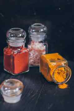 集香料小罐子软木塞盖子粉红色的盐姜姜黄马沙拉红辣椒烟熏红辣椒香料黑色的表面