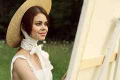 女人白色衣服在户外艺术家画画架