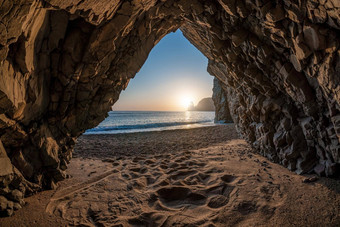 视图石头洞穴日落海海滩火山岩石洞穴基斯温暖的设置太阳火山玄武岩冰岛美世界自然在户外旅行概念