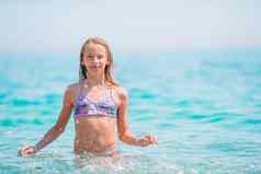 快乐孩子溅波夏天假期热带海滩女孩玩海