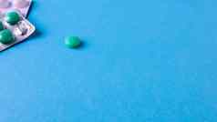 包药片轮药丸一边蓝色的背景复制空间抗病毒平板电脑肺炎细菌感染药物健康治疗