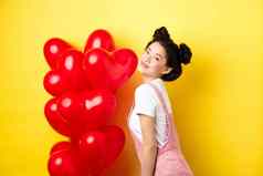 情人节一天的关系概念时尚亚洲女人摆姿势红色的心气球惊喜情人特殊的日期黄色的背景