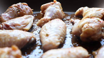 生腌鸡红烧的翅膀锅煎生鸡翅膀烘焙表鸡肉石油香料黑色的锅烹饪过程