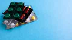 包药片形状颜色堆放蓝色的背景胶囊打包泡包药物药物治疗健康照片复制空间