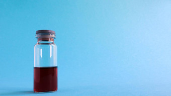 玻璃透明的瓶红色的医学疫苗蓝色的背景医疗主题复制空间医疗疫苗接种概念冠状病毒流感