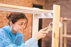 快乐的女人房子画家修复木结构