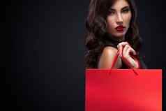 购物女人持有红色的袋孤立的黑暗背景黑色的星期五假期