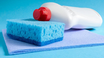 蓝色的海绵白色瓶洗涤剂蓝色的背景方便海绵由好洗涤剂保留在经济上