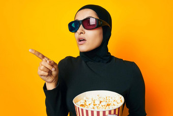 <strong>阿拉伯女人</strong>黑色的戴爆米花眼镜电影黄色的背景