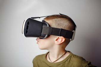 男孩玩移动游戏应用程序设备虚拟现实眼镜白色背景男孩行动虚拟耳机盒子聪明的电话当代技术概念