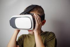 男孩玩移动游戏应用程序设备虚拟现实眼镜白色背景男孩行动虚拟耳机盒子聪明的电话当代技术概念