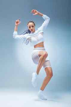 有吸引力的兴奋健身女孩舞者运动服装跳舞孤立的蓝色的背景时尚生活形态概念