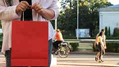特写镜头购物狂女人红色的纸购物袋手作物照片消费主义购物生活方式概念复制空间标志黑色的星期五