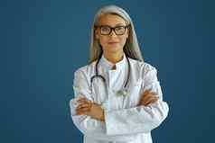 成熟的女医生袍眼镜听诊器站蓝色的背景