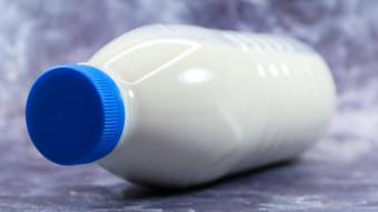 塑料瓶蓝色的帽新鲜的常规的牛奶黑暗灰色的大理石的混凝土背景特写镜头前面视图世界牛奶一天概念营养流体