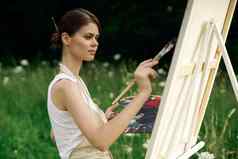 快乐的女人艺术家绘画图片在户外有创意的艺术