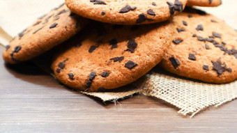 美国巧克力芯片饼干棕色（的）木表格亚麻餐巾特写镜头传统的圆形的脆脆的面团巧克力芯片面包店美味的甜点糕点农村生活