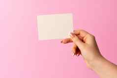 女人手显示空白业务卡粉红色的背景