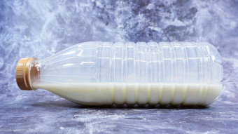 semi-empty塑料瓶新鲜的常规的牛奶谎言黑暗灰色的大理石混凝土背景特写镜头前面视图世界牛奶一天概念营养流体