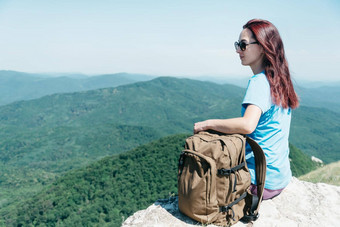 背包客女人坐着高夏天山