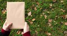 关闭书封面使工艺纸女手绿色草下降黄色的叶子背景平躺前视图模板布局复制空间