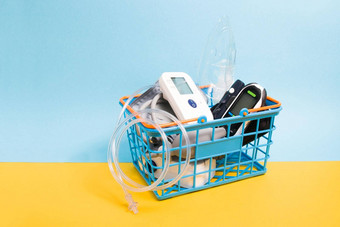 医疗设备首页小蓝色的购物篮子瞳背景复制空间葡萄糖计吸入喷雾器测量血压力监控在线购物概念