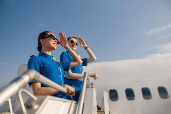 肖像优雅的空气<strong>空姐</strong>蓝色的统一的太阳镜覆盖眼睛手站空中楼梯