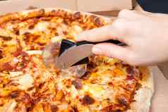 关闭手切割披萨披萨刀美味的paperoni披萨开放盒子孤立的黑色的背景前视图paperoni披萨概念意大利食物街食物快食物快速咬