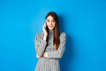 时尚的年轻的女人会说话的电话使外卖<strong>订单</strong>智能<strong>手机</strong>站衣服蓝色的背景