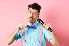 聚会，派对节日事件概念有趣的的家伙唱歌卡拉ok执行首歌麦克风喝香槟玻璃站粉红色的背景