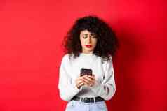 伤心担心女人阅读消息智能手机收到坏新闻社会媒体站红色的背景