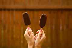 夏天甜蜜的食物女手持有巧克力冰奶油棕色（的）背景