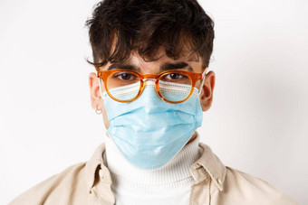 头像年轻的的家伙眼镜无菌医疗面具快乐的动机站白色背景社会距离冠状病毒概念