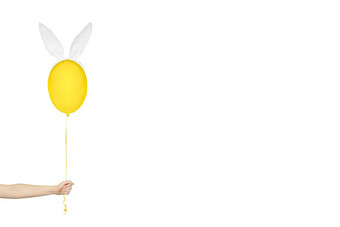 有创意的复活节最小的概念手持有黄色的气球兔子耳朵孤立的白色单色横幅复制空间