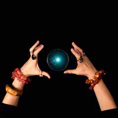 《财富》杂志出纳员女巫手发光的魔法球孤立的黑暗背景万圣节魔法技巧概念