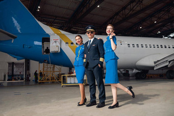 完整的长度拍摄飞行员统一的飞行员太阳镜站空气空姐蓝色的统一的前面大乘客飞机机场机库