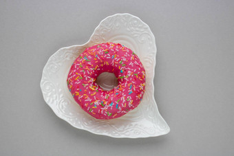 甜甜圈色彩斑斓的洒孤立的说谎白色板灰色的背景前视图