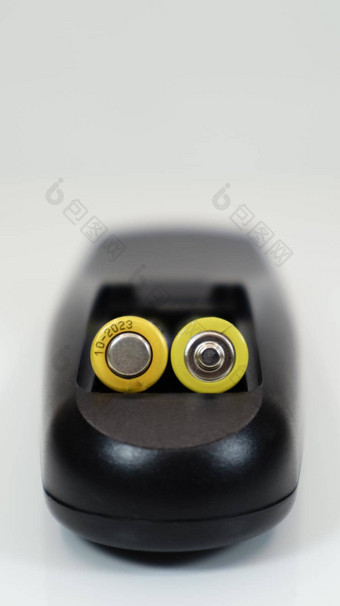 黑色的远程控制黄色的aaa电池白色背景电池更换备用部分远程控制电池室特写镜头垂直摄影