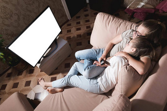 年轻的种子夫妇看电影说谎沙发晚上公寓碗爆米花屏幕减少设计师空白宽角