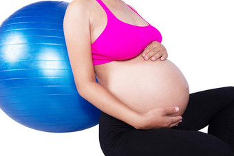 特写镜头肚子怀孕了女人健身球白色背景